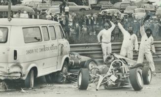 Waving other drivers past, three race marshall the wreckage of the racing car in which Wayne Kelly, 37, was decapitated at Mosport Park yesterday afte(...)