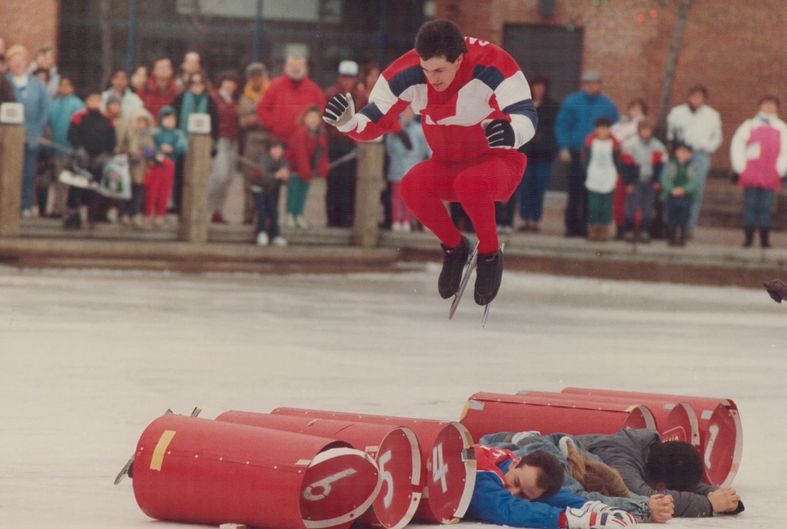 Pierre Buist sails over three brave volunteers and six barrels as he competes in a jumping competition at Harbourfront yesterday. He later cleared 14 (...)