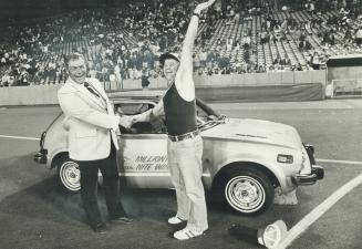 Car-winning Jays fan Bert Hynes waves to baseball crowd at Exhibition Stadium last night after being presented with a new car by John Russell, a Canad(...)