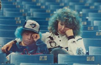 Blue-haired Lois Magwood, 40, and son Ian, 11, are dejected after the Jays' heart-breaking 6-5 loss to the A's