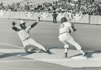 Expos' Ellis Valentine looks apprehensive, but beat the throw to Roy Howell at third base