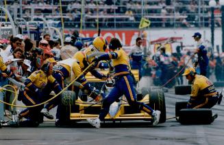 A pit crew works frantically at last year's Molson Indy (above)