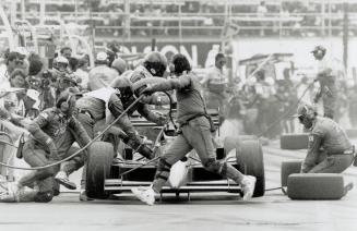 Let's get busy: The crew for driver Bobby Rahal, who placed third in yesterday's Indy-car race, swarms purposefully around his vehicle during a pit stop