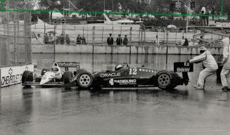 Wet win: Al Unser Jr., the ultimate winner of the rain-soaked Molson Indy (on the left), slips past Randy Lewis, who gets some help from a marshal, on a very slick Lake Shore track