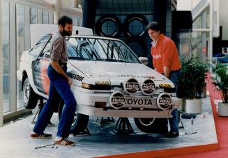 Finding a good parking spot. Performance rally drivers Niall Leslie and Stuart Ballntyne pretend to lift a car as they help set up the Toyota display (...)