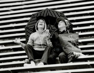 Play ball! It wasn't the greatest weather for a ball game, but these two young Blue Jay fans were all smiles when yesterday's rain subsided into a mere drizzle by game time