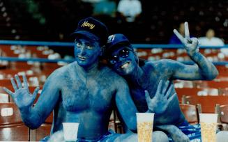 Some fans will go to extremes. The pair at left not only followed the Blue Jays (below, in their pre-game stretch at Municipal Stadium) to Cleveland, but also painted themselves true blue