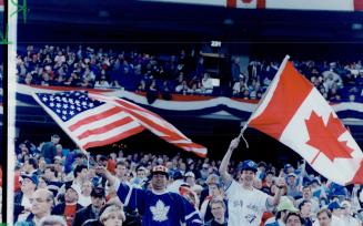 Fans aflutter: SkyDome flags fly - right side up - at last night's World Series game, won 3-2 by the Blue Jays
