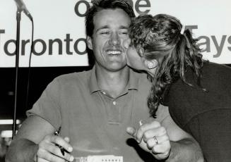 Jay fanatics: Rina Farace, left, is thrilled after meeting Blue Jays Pat Borders at a Mississauga mall, while the catcher is all smiles after a kiss from Michelle Lavingne