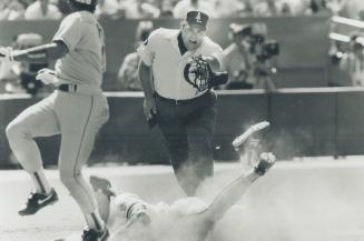 Gotcha: Jays third baseman Kelly Gruber pursues, dives and tags scrambling Rex Sox catcher Tony Pena in the seventh inning after he was caught rounding third base and tried to hot-foot it home