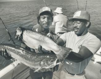 Jays' Lloyd Moseby, left, and Willie Upshaw proved yesterday they can make some pretty good catches - the underwater variety, that is. Off Port Credit(...)