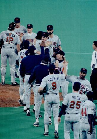 High-five parade: Minnesota Twins congratulate each other after closer Rick Aguilera set down the Jays in order in the 10th inning to preserve a 3-2 win