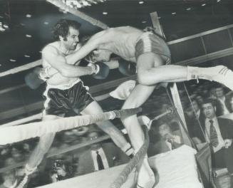 Furious Onslaught by Lou Bizzarro of Akron, Ohio, shoves Toronto's Don Bolter partially through ropes during last night's 8-round main event of boxing(...)