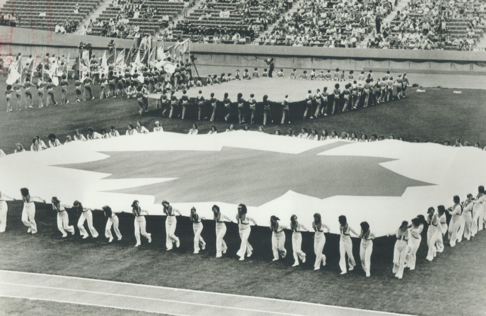 A huge Canadian flag is put together on centre field of the new Commonwealth Stadium in Edmonton during opening day rehearsal