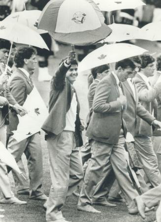 Geoff Hurst, a dirver from Etobicoke, waves his Blue Jays umbrella in the opening parade of the Commonwealth Games yesterday. Today, Canadians Sharon (...)