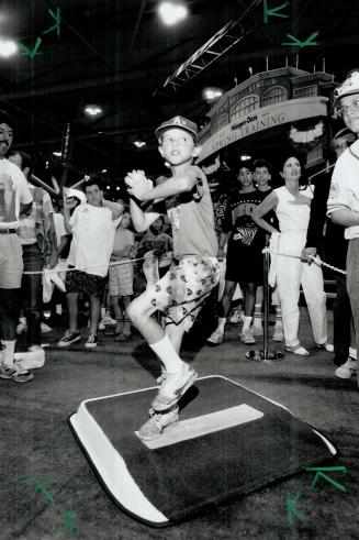 Big windup: Eight-year-old Chris Simpson goes into his major-league windup yesterday while trying out game called The Bullpen at All-Star Game FanFest