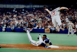 Hats off: Speedy Blue Jay baserunner Devon White loses his batting helmet as he slides into third base under a leaping Mike Pagliarulo