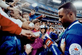 Blue Jays' injured right fielder Joe Carter autographs baseballs last night for fans at the SkyDome as Toronto prepared to play the Minnesota Twins
