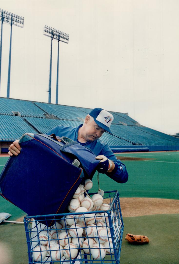 Coach John Sullivan (above) fills up the pitching hopper so his boss Jimy Williams can pitch batting practice