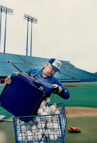 Coach John Sullivan (above) fills up the pitching hopper so his boss Jimy Williams can pitch batting practice