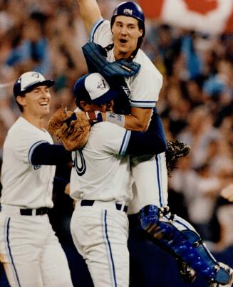 Jubilant Pat Borders leaps into arms of Tom Henke as John Olerud rushes to join in