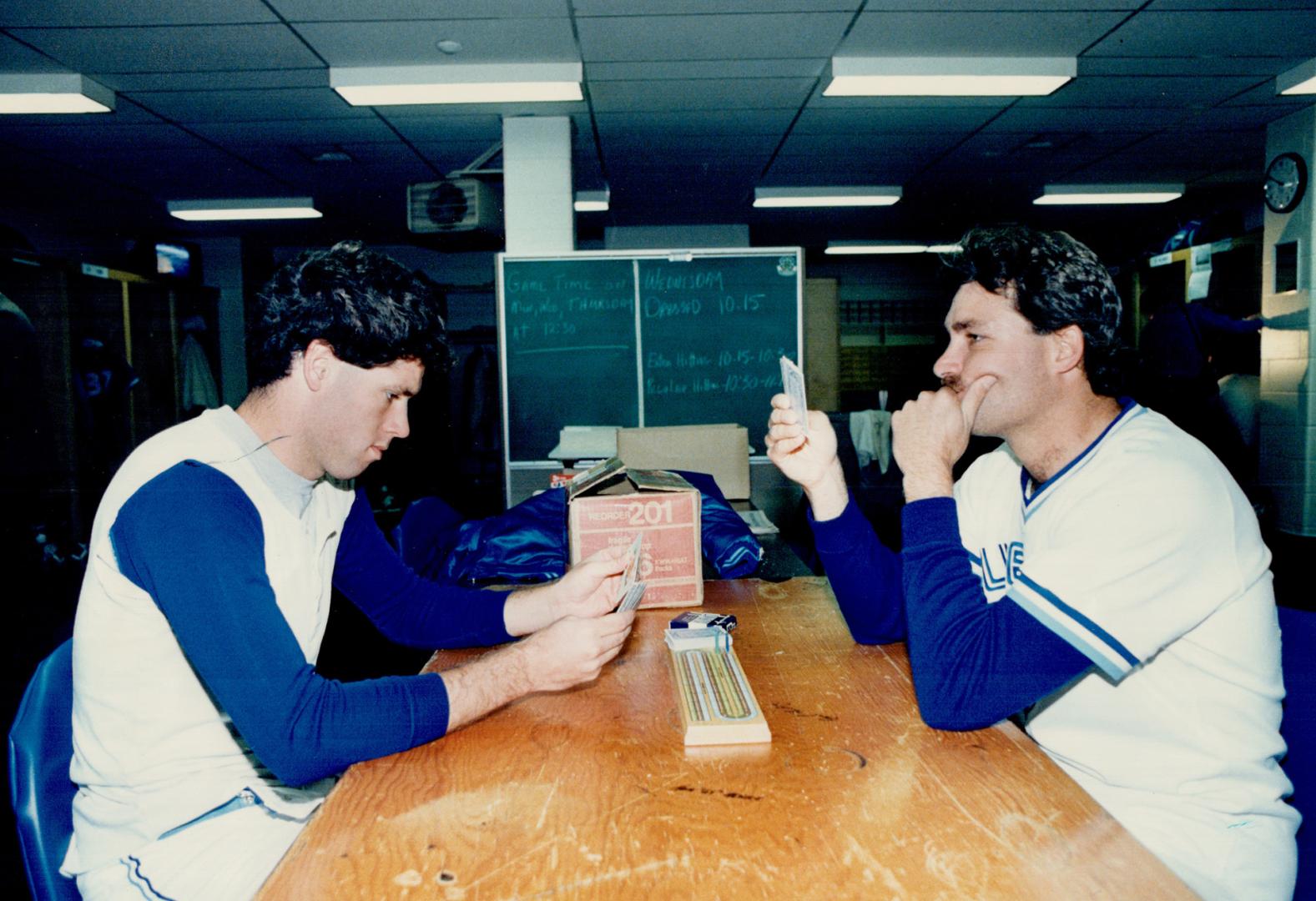 John Cerutti and Dave Stieb ponder their luck in a serious game of cribbage, a favorite pre-game and post-game pastime