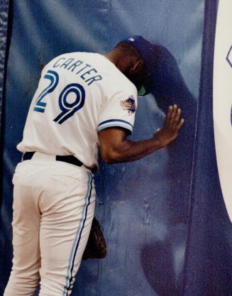 Slam dance: Blue Jays' outfielder Joe Carter leans his head against the wall last night after Atlanta's Lonnie Smith smacked a grand slam homer to win it 7-2
