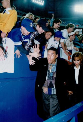 Home again: Outfielder Candy Maldonado, who swung a big bat during the series, greets fans on his way into SkyDome wife wife Norma