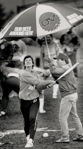 No rainouts here: Kim Black provides the umbrella while Christel Waite provides the bat power for Aylmer Universal Jays, one of 500 teams taking part in a sio-pitch tourney