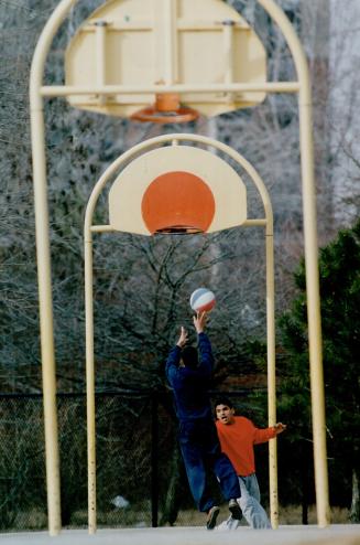 The good weather brought Dale Angel, 21, poised to shoot the ball through the hoop, and Neil Persaud, 15, out to the basketball court at Bella Vista P(...)