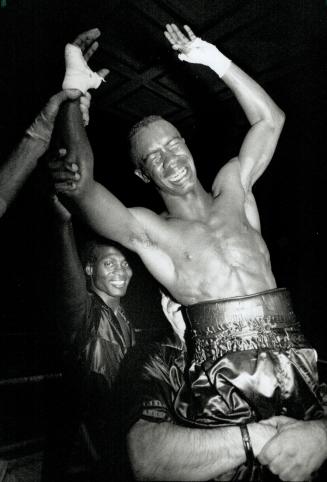 Feather Light: Barrington Francis of Toronto is hoisted into the air by manager Raymond Rutter after winning the Commonwealth featherweight title