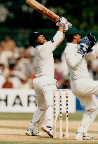Sky high: India's Sachin Tendulkar skies one behind the wicket as Pakistan wicketkeeper Moin Khan dances in anticipation of an out that didn't come