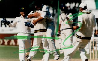 Party time: Pakistan wicketkeeper Moin Khan, left, and bowler Azhar Mehmood, right, join teammate in celebration after taking Indian wicket yesterday