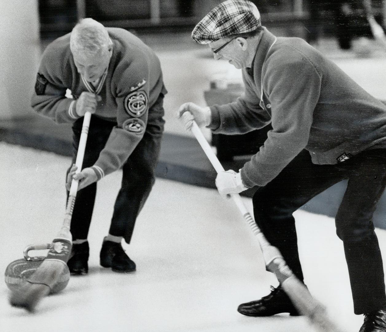 Bun Cooke (left) and Ed Kirk work on skip Charlie Semple's rock in a match against the High Park rink of Jack Wilson in Ontario Curling Association Se(...)