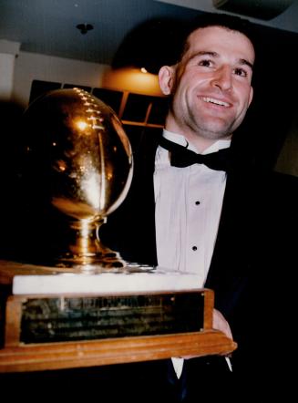Top of his game: University of Toronto quarterback Eugene Buccigrossi shows off the Hec Crighton Trophy he won last night at awards ceremony