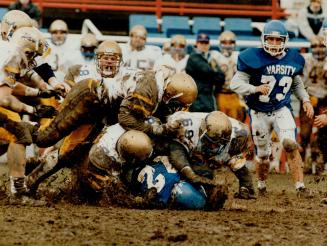 Here's mud in your eye. No doubt, running back Mike Catalano of the U of T Blues wanted a convenient place to hide on this play, but he was out of luc(...)