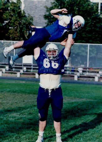 Full body press: Central Tech's Belchoit Arruda, all 6-foot-4 and 285 pounds of him, gives 5-foot-2, 135-pound teammate Joe Fonseca a lift