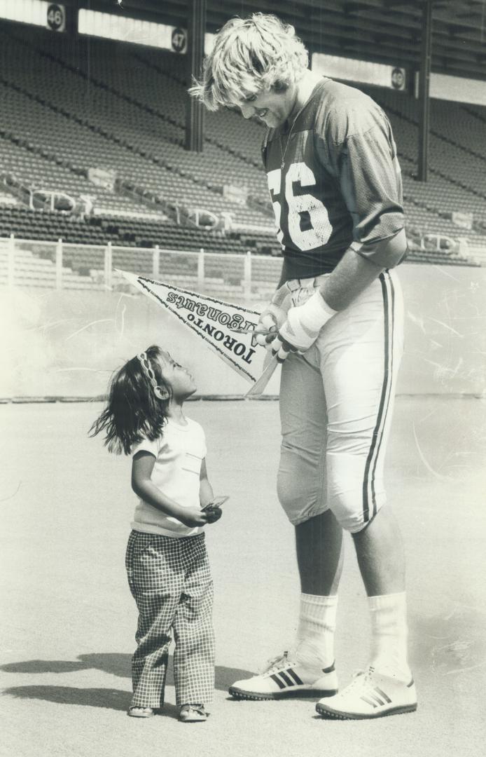 Sign it with love. Trishia Consunju, 4, gets a smile and an autograph from Argo rookie lineman John Foubert at CNE Stadium yesterday. Hundreds of disa(...)