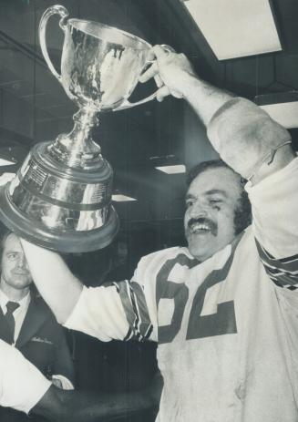 The ecstasy...and. It's great: Moe Racine, the lumbering giant who is co-captain of the Ottawa Rough Riders, lifts the Grey Cup in triumph after yeste(...)
