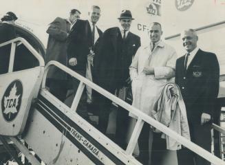 Led by coach Bud Grant (right), members of the Western Canadian champion Winnipeg Blue Bombers file off their plane at Malton today to prepare for the(...)
