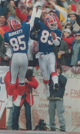 Now that's a high five! Buffalo receivers Chris Burkett (85) and Andre Reed whoop it up in AFC playoff game against Houston Oilers yesterday at Rich Stadiu,. Bills won 17-10