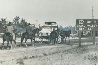 En route to the grey cup by stagecoach, escorted by outriders, a group of football fans from Kincardine moves down highway to Toronto where they are s(...)