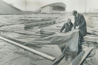 Verdict: Soggy. That' what Jim Brown (left) works manager for the CNE, and Bill Sheffield, assistant works manager, decided after lifting a corner of (...)