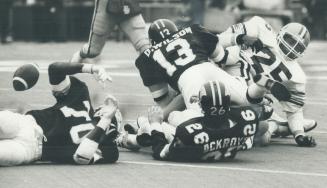 Though Jim Germany of the Eskimos has just coughed up the ball, it refuses to take 'the Argo Bounce' into the waiting arms of three Toronto defenders