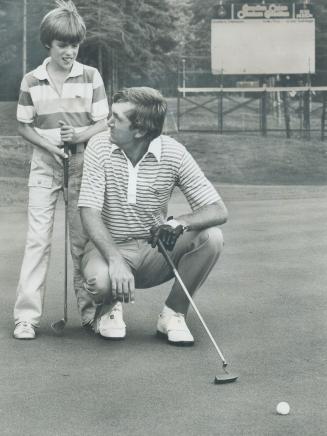 What do you think? Al Geiberger gets a second opinion about which way a putt will break, asking his son Brent, 9, for advice on the putting green at G(...)
