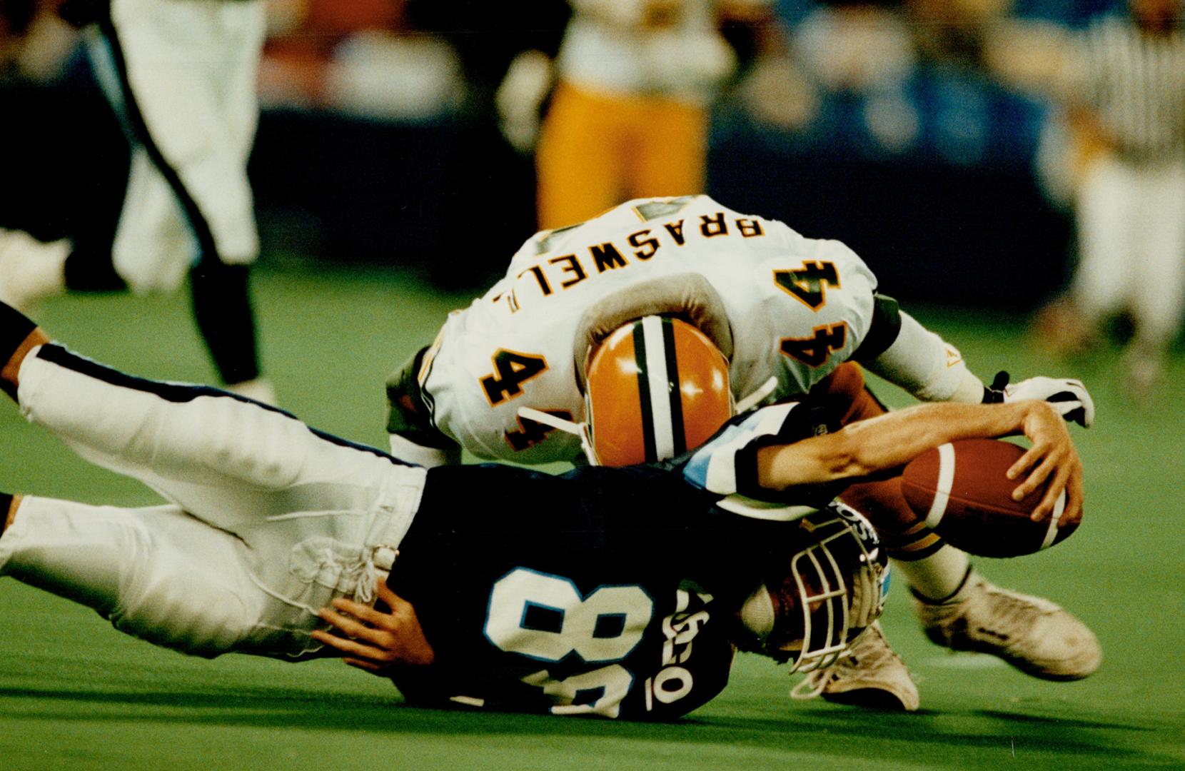 Stick 'em: Eskimos linebacker Jeff Braswell does just that to Argos receiver Paul Masotti last night, making Masotti pay after a completed pass
