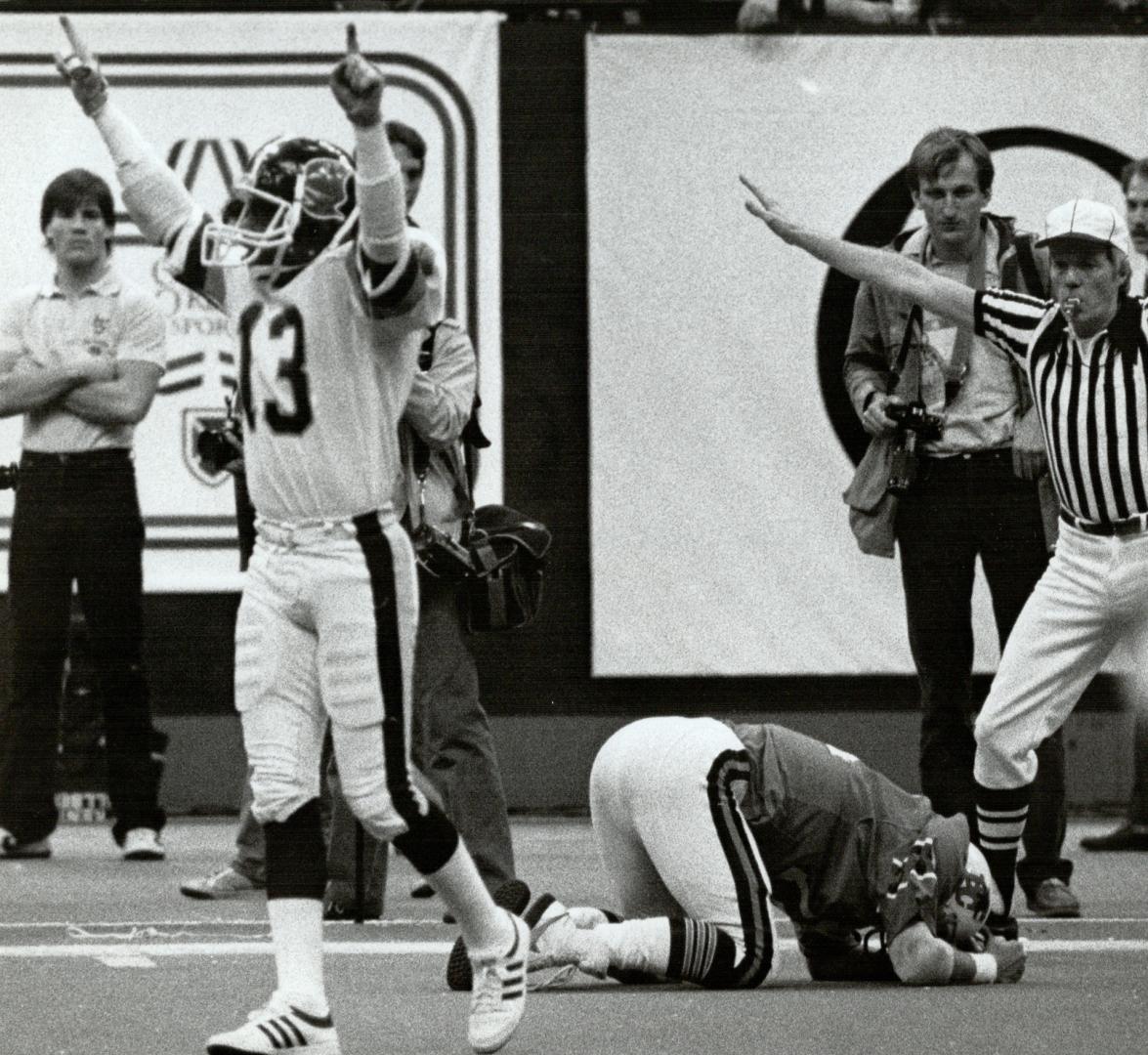 Argos Darrell Wilson signals number 1 as Lions Jacques Chapdelaine buries his head after missing a pass that might have won them the Grey Cup game here 11/27