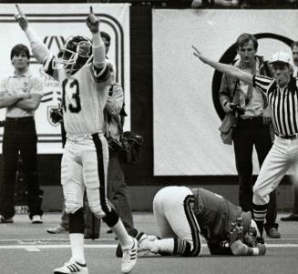 Argos Darrell Wilson signals number 1 as Lions Jacques Chapdelaine buries his head after missing a pass that might have won them the Grey Cup game here 11/27