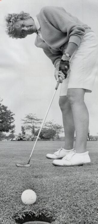 Kay Helleur putts out at Whitevale Golf Club on her way to the Toronto and district women's golf championschip yesterday. Miss Helleur shot a women's record 76
