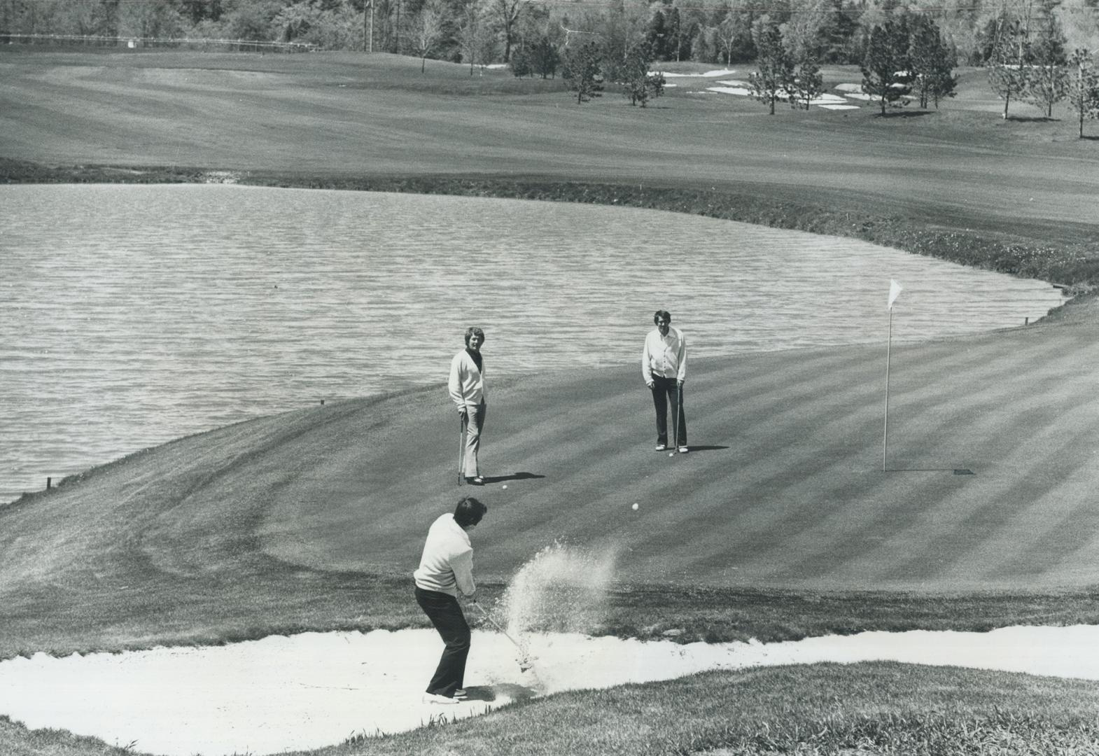 On the beach, Club pro Bobby Breen tests sand traps on final hole at Glen Abbey golf course near Oakville